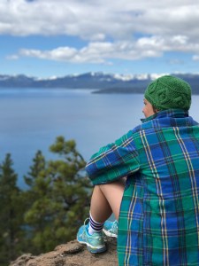 Bonnie sitting overlooking Lake Tahoe wearing flannel and knit hat