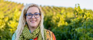 Bonnie Shea headshot in vineyard wearing green scarf